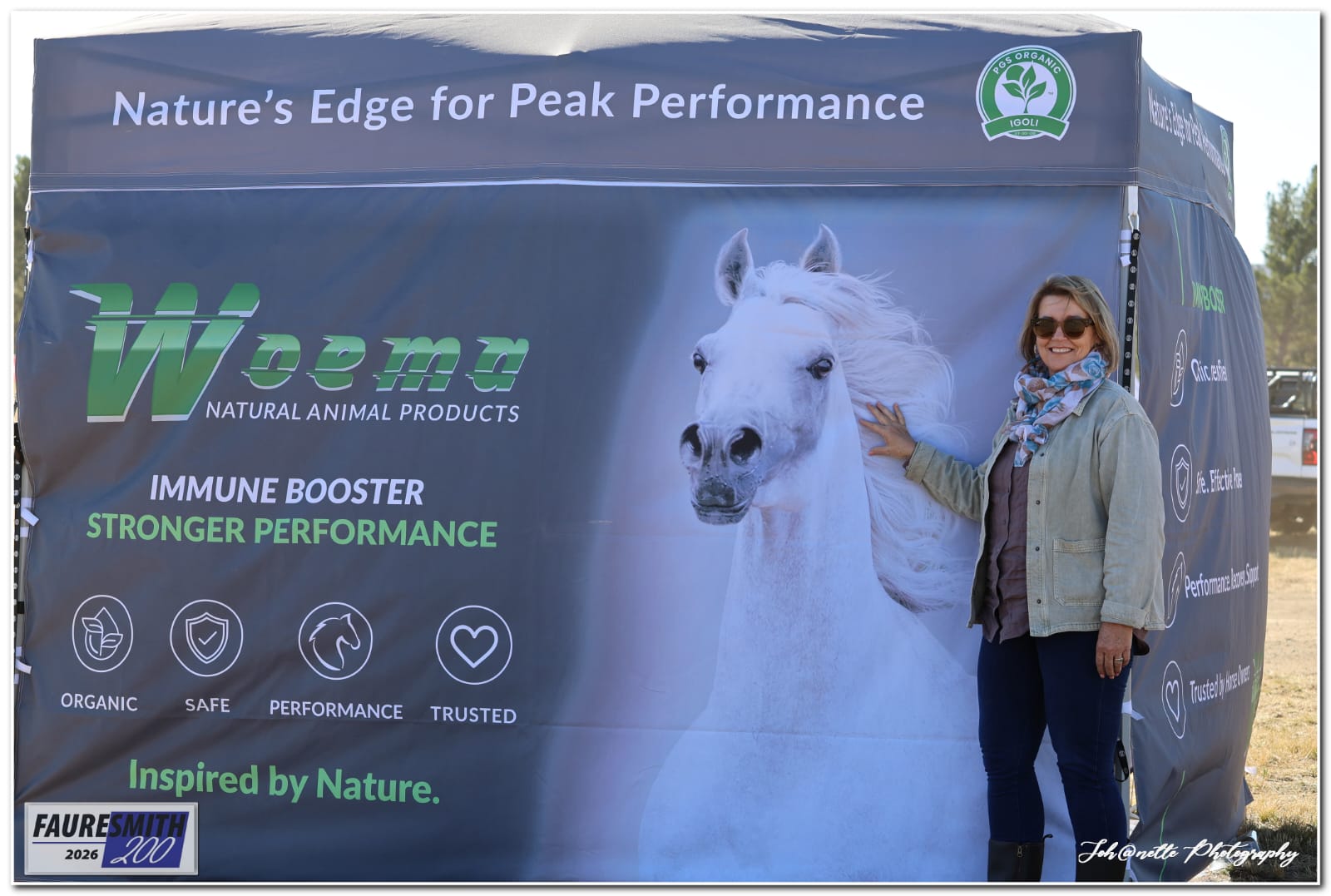 A visitor in front of the WOEMA gazebo and white horse banner at Fauresmith 2026